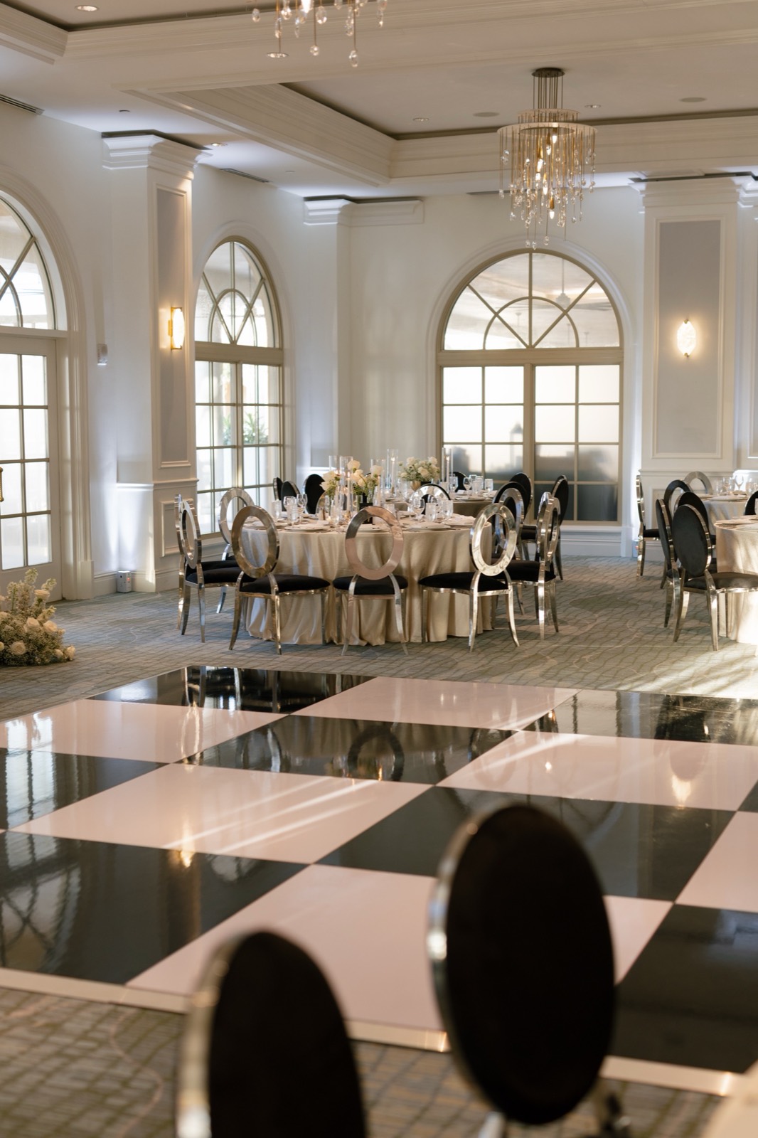 Ballroom reception with black and white dance floor and silver chairs
