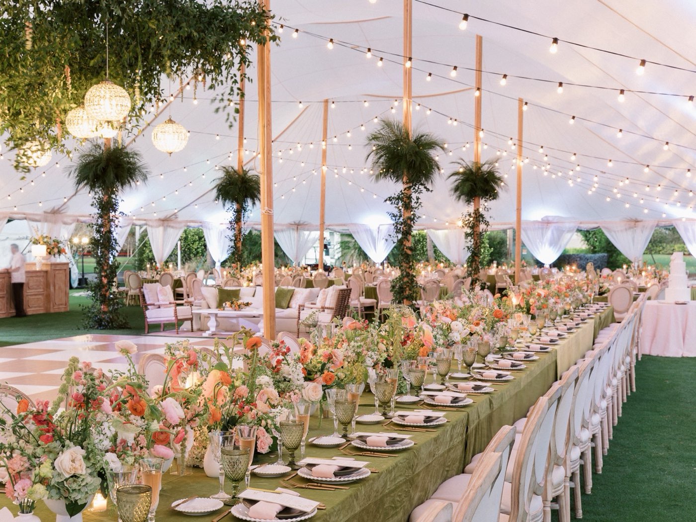 Tent reception with floral tablescape and lounge furniture